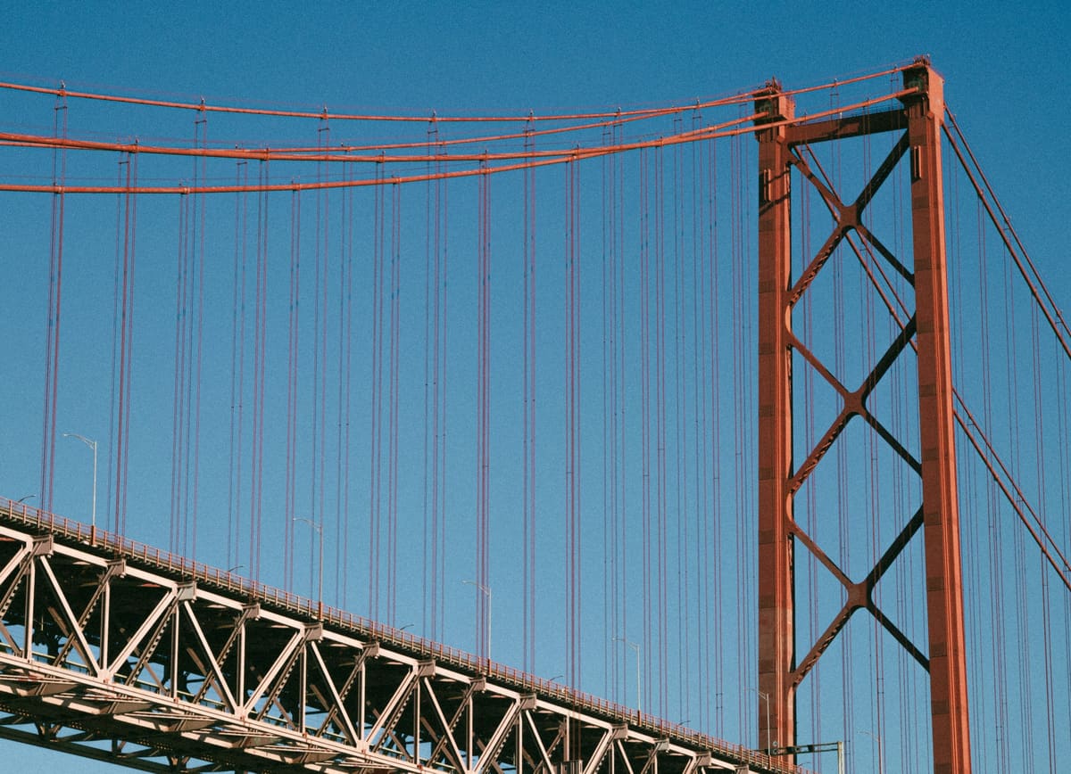 Suspension bridge tower and cables against a blue sky